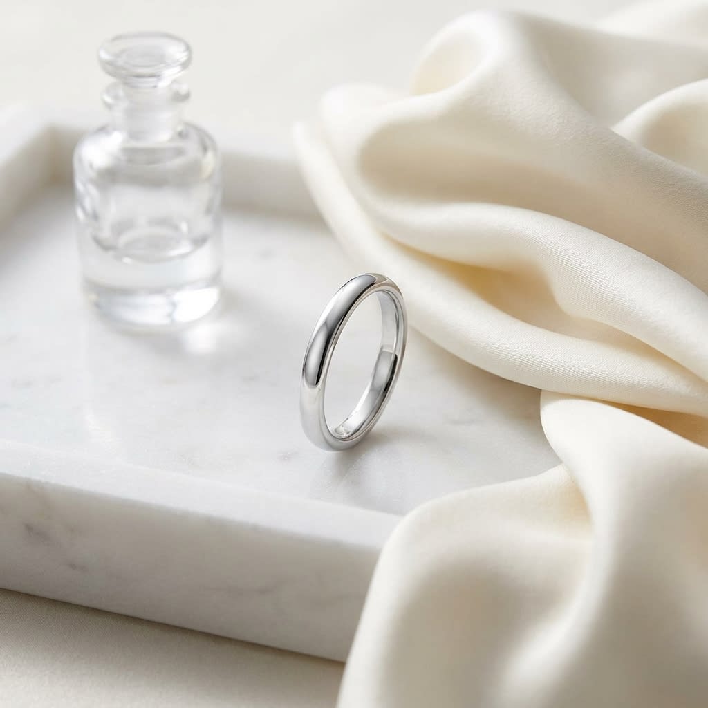 2.5mm Slightly Domed Traditional Oval Wedding Band in Platinum, on marble vanity tray with silk