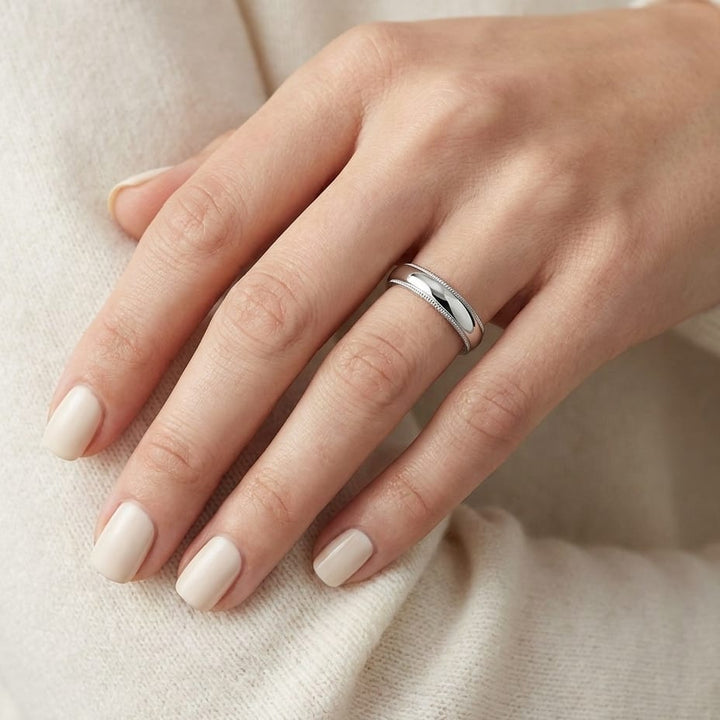 4mm Slightly Domed Traditional Oval Milgrain Wedding Band in Platinum, worn on hand, close-up
