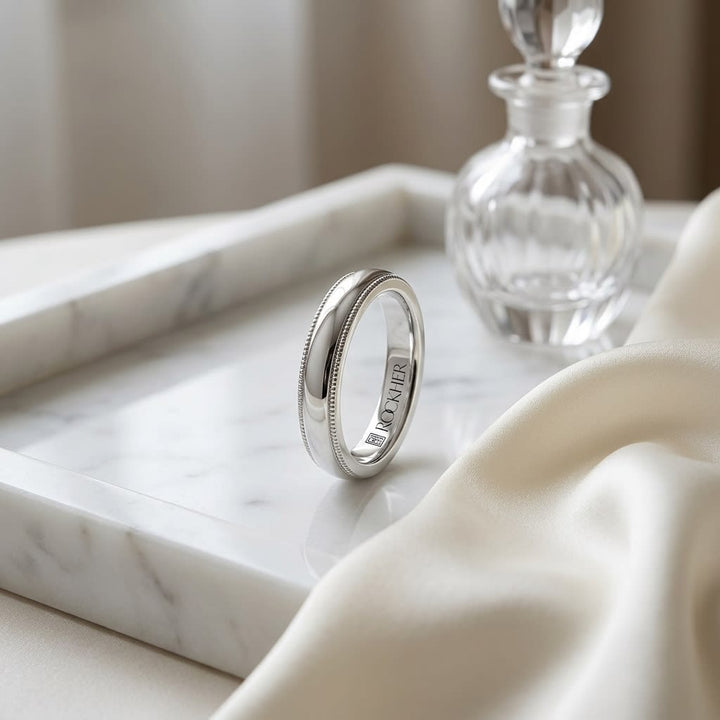 4mm Slightly Domed Traditional Oval Milgrain Wedding Band in Platinum, on marble vanity tray with silk
