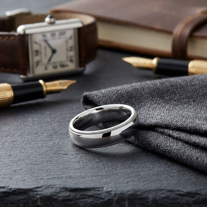 5mm Slightly Domed Traditional Oval Milgrain Wedding Band in Platinum, on walnut surface with pocket square