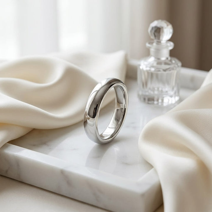 4mm High Dome Comfort-Fit Wedding Band in Platinum, on marble vanity tray with silk