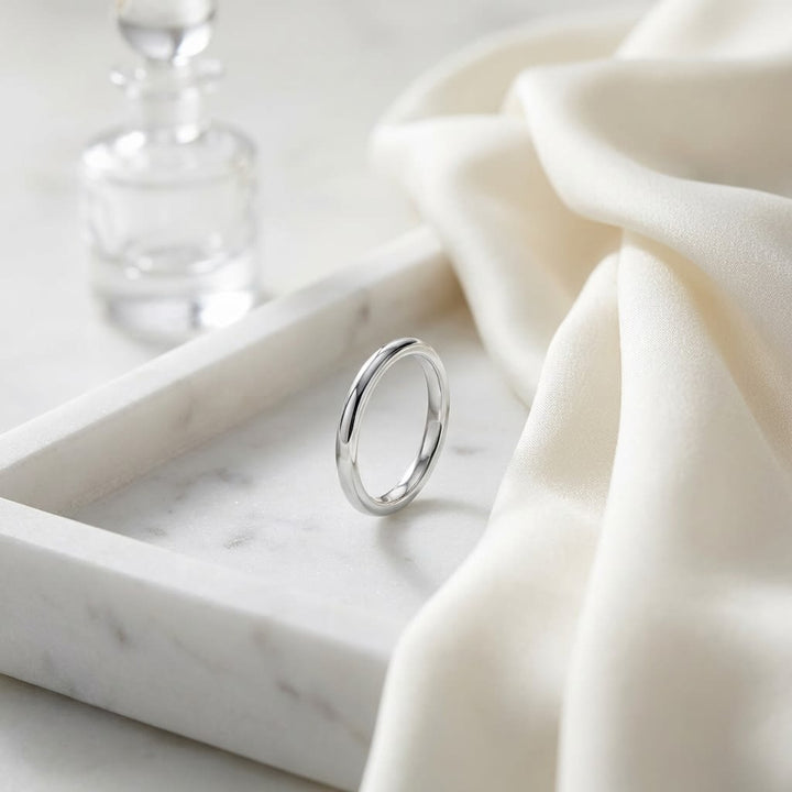 2mm Slightly Domed Comfort-Fit Wedding Band in Platinum, on marble vanity tray with silk