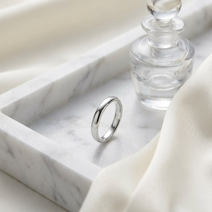 2.5mm Slightly Domed Comfort-Fit Wedding Band in Platinum, on marble vanity tray with silk