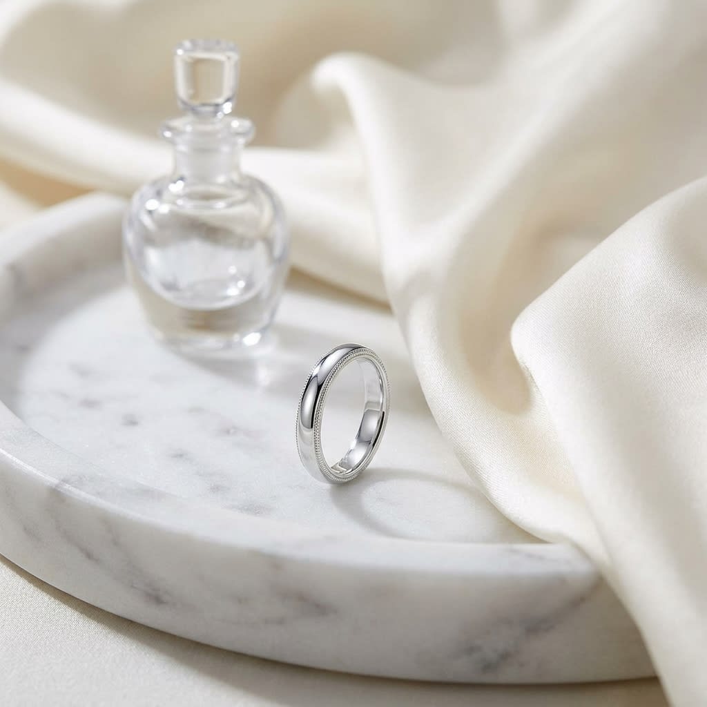 4mm Slightly Domed Milgrain Comfort-Fit Wedding Band in Platinum, on marble vanity tray with silk