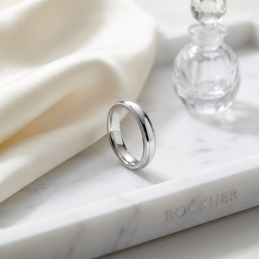 4mm Slightly Domed Double Milgrain Comfort-Fit Wedding Band in Platinum, on marble vanity tray with silk