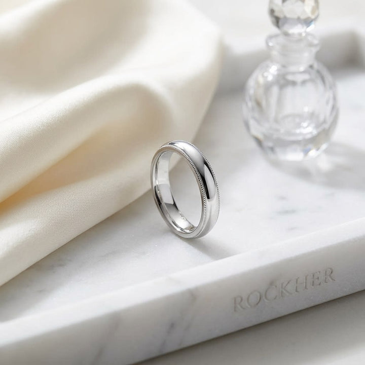 4mm Slightly Domed Double Milgrain Comfort-Fit Wedding Band in Platinum, on marble vanity tray with silk
