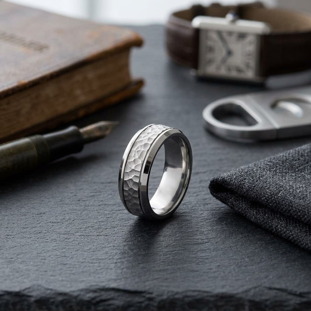 7.5mm Hammered Finish Beveled Edge Carved Wedding Band in Platinum, on walnut surface with pocket square