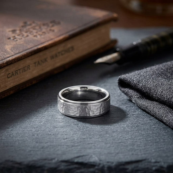 6mm Hammered Finish Carved Wedding Band in Platinum, on walnut surface with pocket square