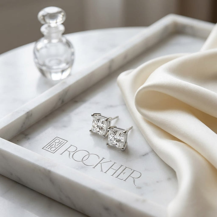 Natural Diamond Princess Cut Four Prong Stud Earrings in Platinum, 1/2 ct. t.w., on marble vanity tray with silk