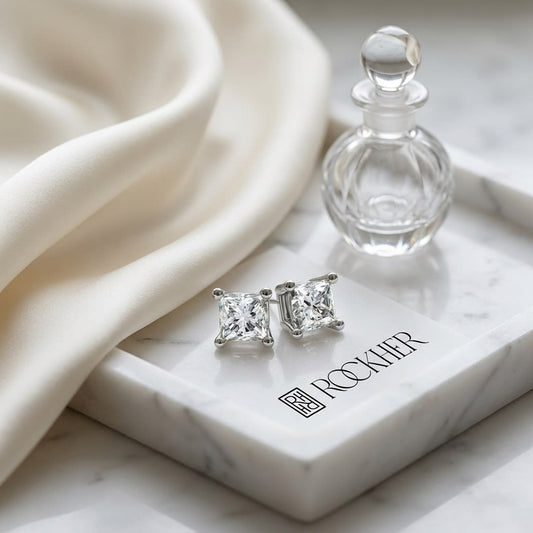 Natural Diamond Princess Cut Four Prong Stud Earrings in Platinum, 1/2 ct. t.w., on marble vanity tray with silk