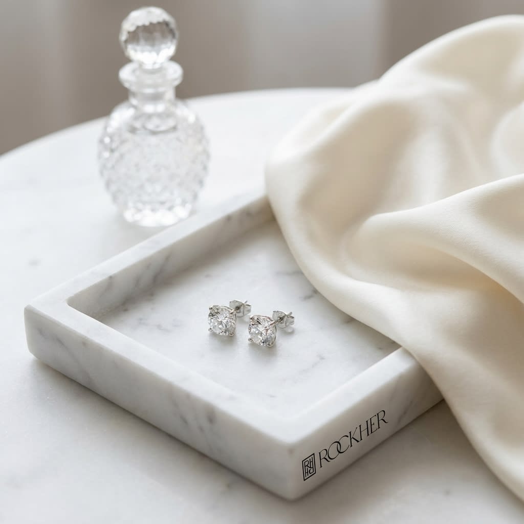 Natural Diamond Round Brilliant Four Prong Stud Earrings in Platinum, 1-1/2 ct. t.w., on marble vanity tray with silk