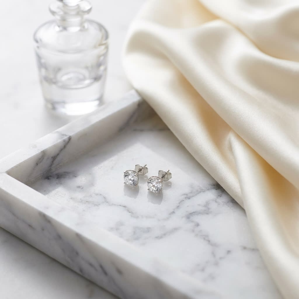 Platinum Bezel Set Round Brilliant Diamond Stud Earrings (0.22 Ct. T.w., Vs1-vs2 Clarity, H-i Color), on marble vanity tray with silk