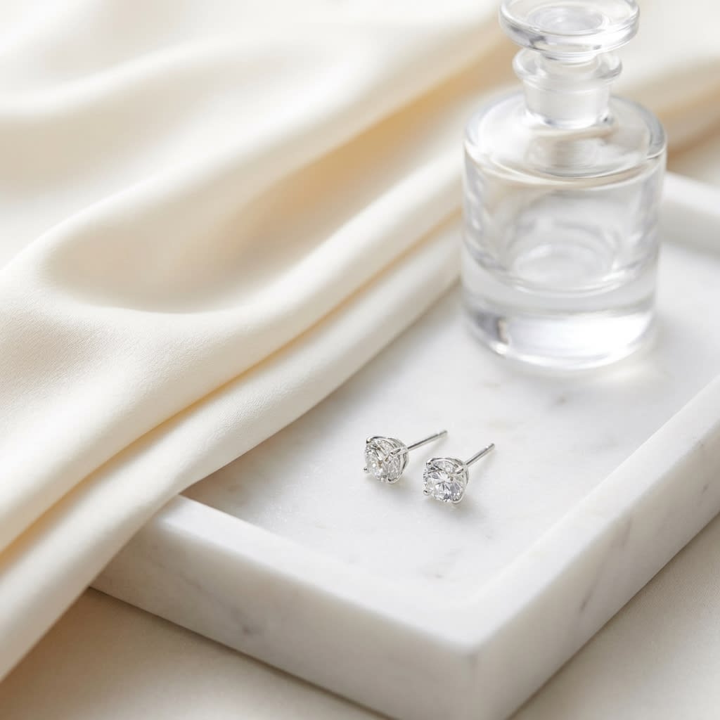 Natural Diamond Round Brilliant Bezel Stud Earrings in Platinum, 2 ct. t.w., on marble vanity tray with silk