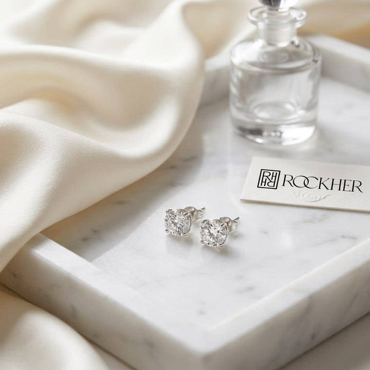 Platinum Bezel Set Round Brilliant Diamond Stud Earrings (0.52 Ct. T.w., Si1-si2 Clarity, H-i Color), on marble vanity tray with silk