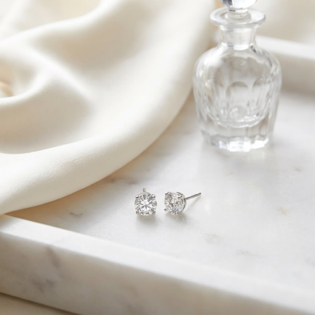 Platinum Bezel Set Round Brilliant Diamond Stud Earrings (1.06 Ct. T.w., Vs1-vs2 Clarity, H-i Color), on marble vanity tray with silk