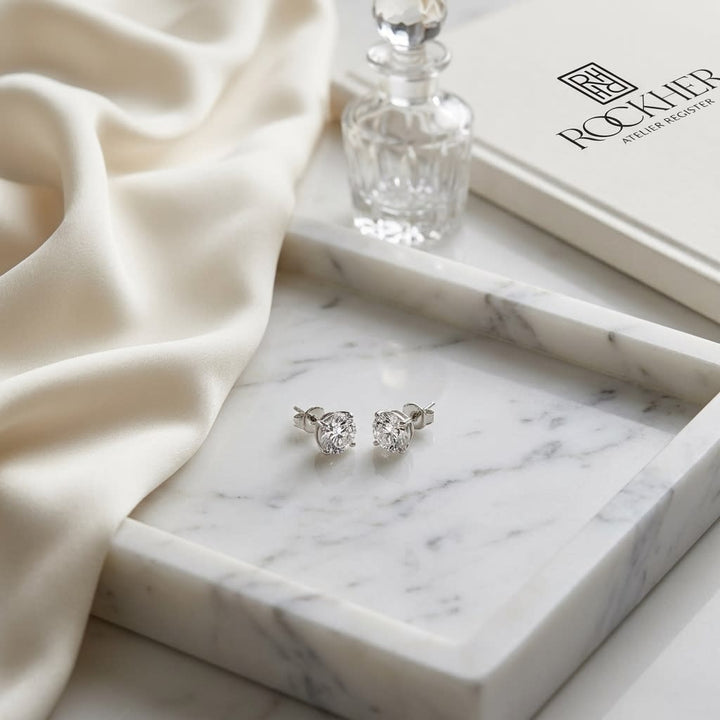 Natural Diamond Round Brilliant Bezel Stud Earrings in Platinum, 1 ct. t.w., on marble vanity tray with silk