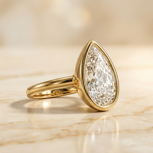 The Agnes Select bezel solitaire briolette engagement ring in 18k yellow gold — alt-angle hero — RockHer