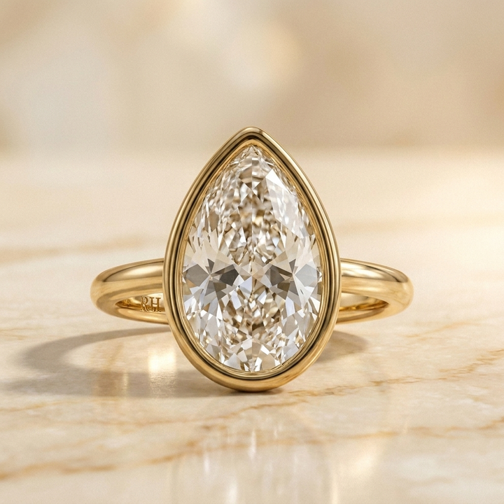 The Agnes Select bezel solitaire briolette engagement ring in 18k yellow gold — front view — RockHer