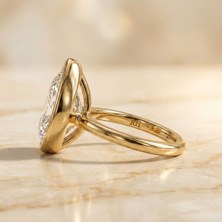 The Agnes Select bezel solitaire briolette engagement ring in 18k yellow gold — side profile — RockHer