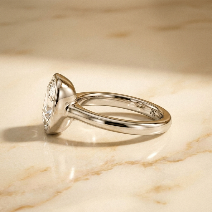 The Agnes Select bezel solitaire cushion engagement ring in platinum — side profile — RockHer