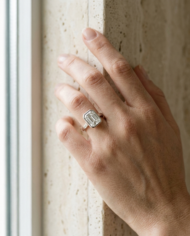 The Agnes Select bezel solitaire emerald cut engagement ring in 18k white gold — on hand — RockHer