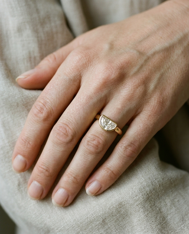 The Agnes Select bezel solitaire half cut engagement ring in 18k yellow gold — on hand — RockHer