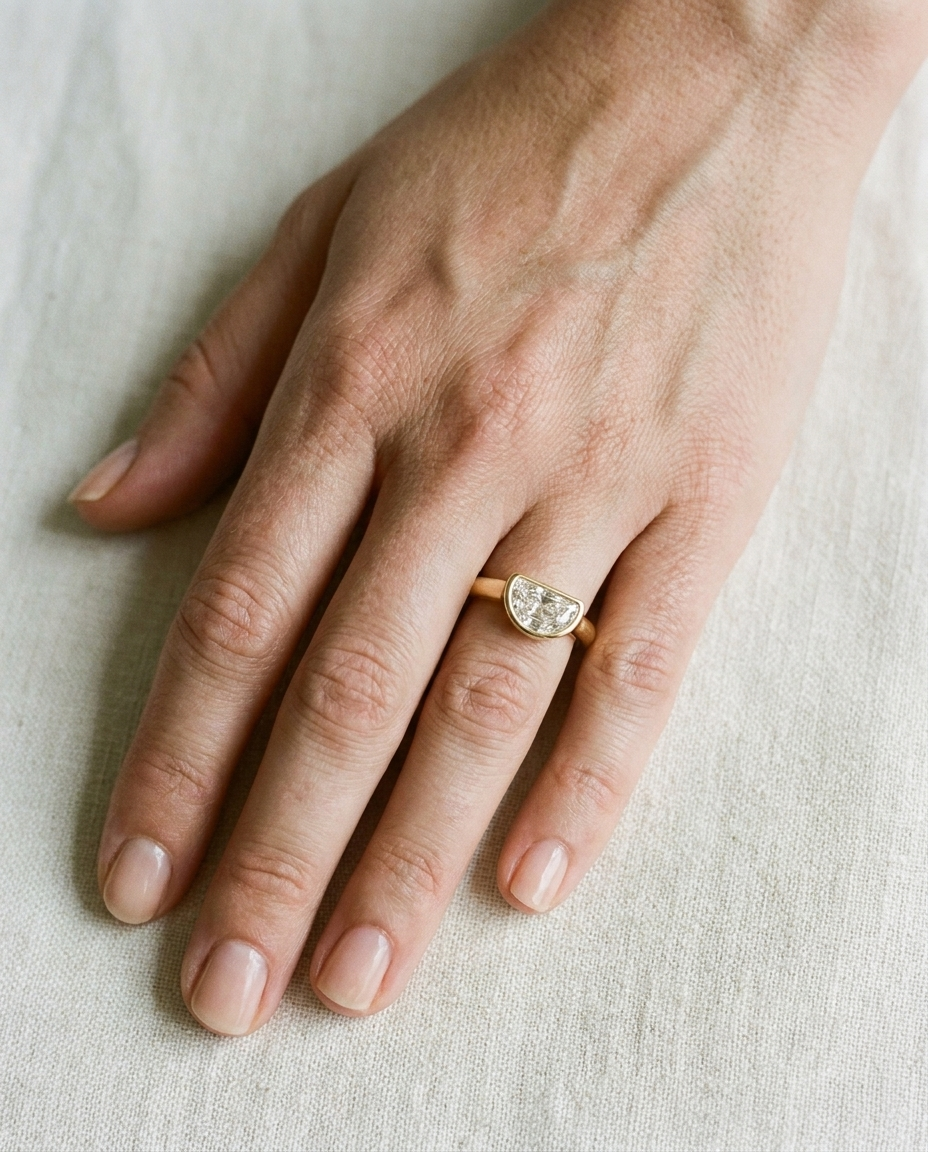 The Agnes Select bezel solitaire half cut engagement ring in 18k yellow gold — top down hand — RockHer