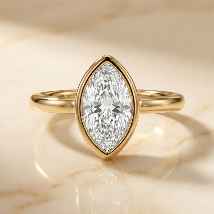 The Agnes Select bezel solitaire marquise engagement ring in 18k yellow gold — front view — RockHer