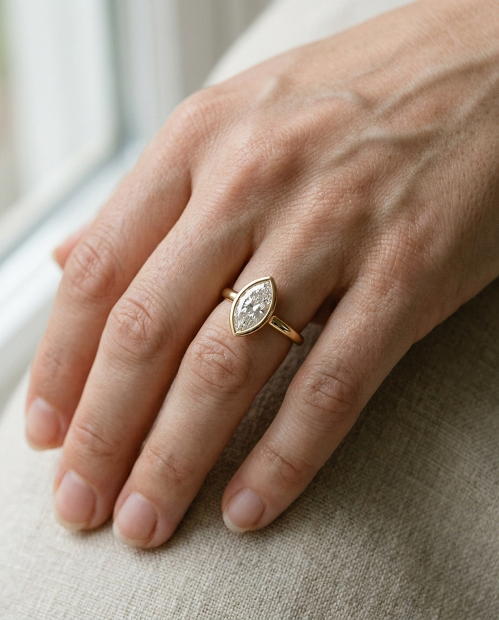 The Agnes Select bezel solitaire marquise engagement ring in 18k yellow gold — on hand — RockHer