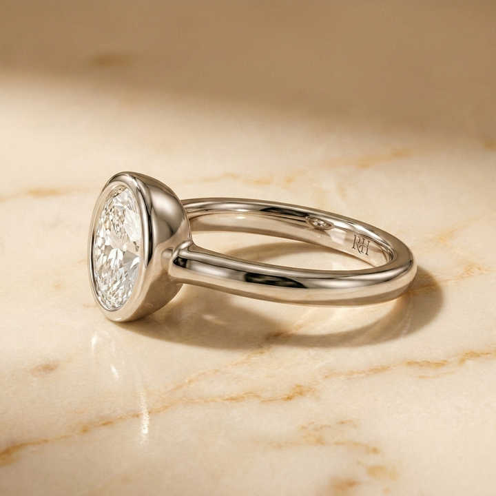 The Agnes Select bezel solitaire oval engagement ring in platinum — side profile — RockHer