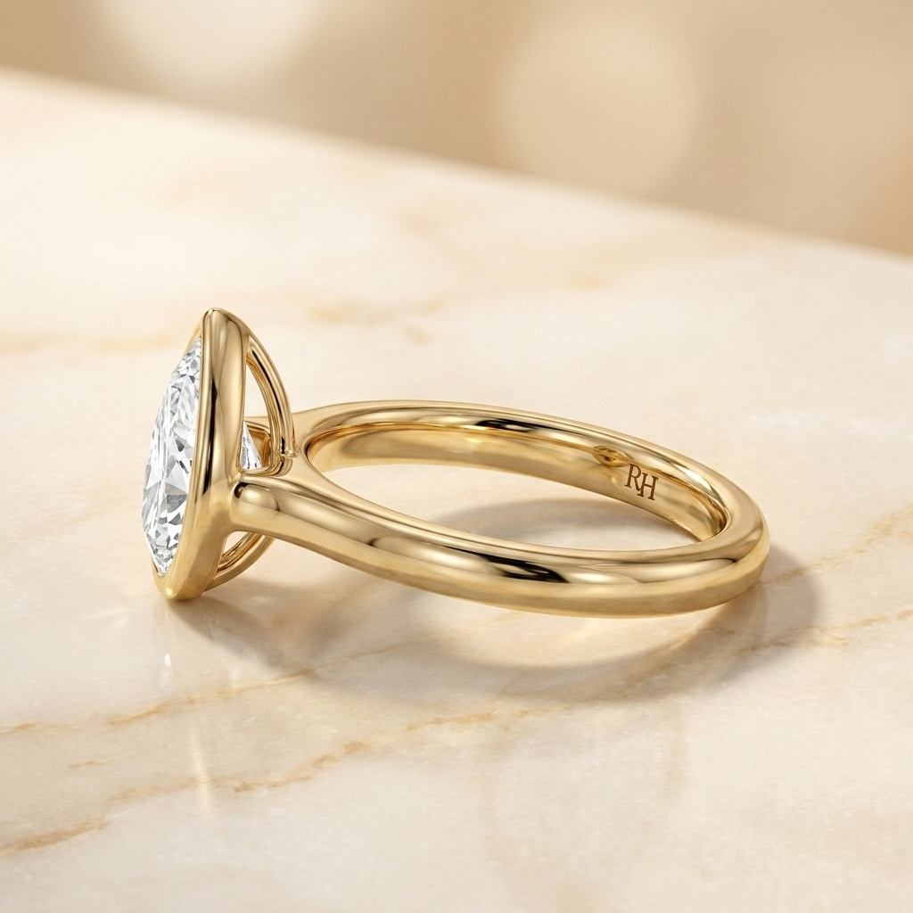 The Agnes Select bezel solitaire pear engagement ring in 18k yellow gold — side profile — RockHer
