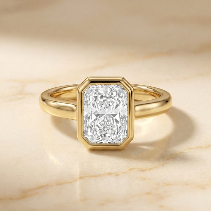 The Agnes Select bezel solitaire radiant engagement ring in 18k yellow gold — front view — RockHer