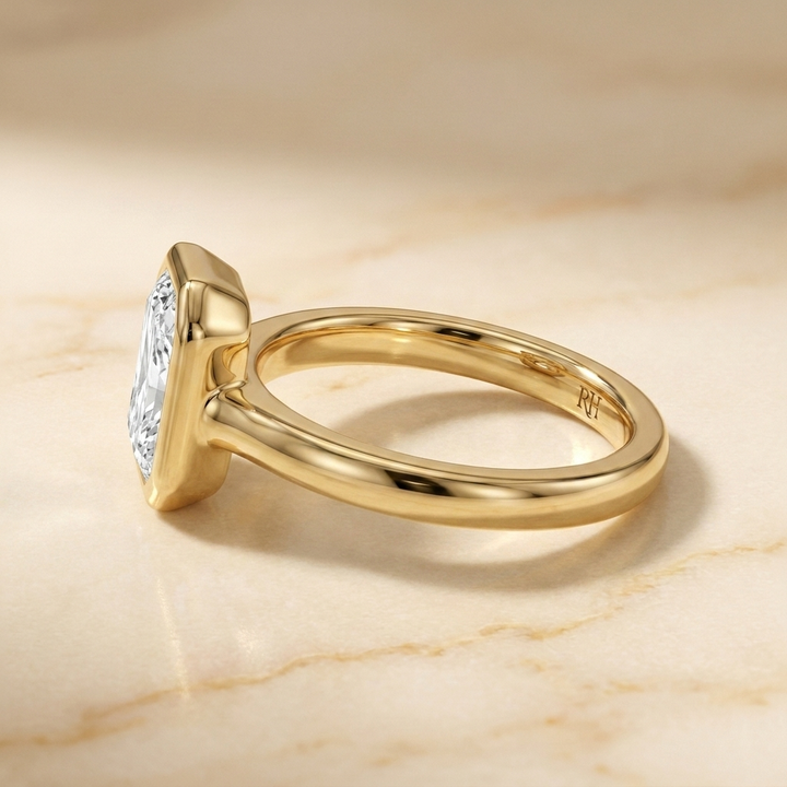 The Agnes Select bezel solitaire radiant engagement ring in 18k yellow gold — side profile — RockHer
