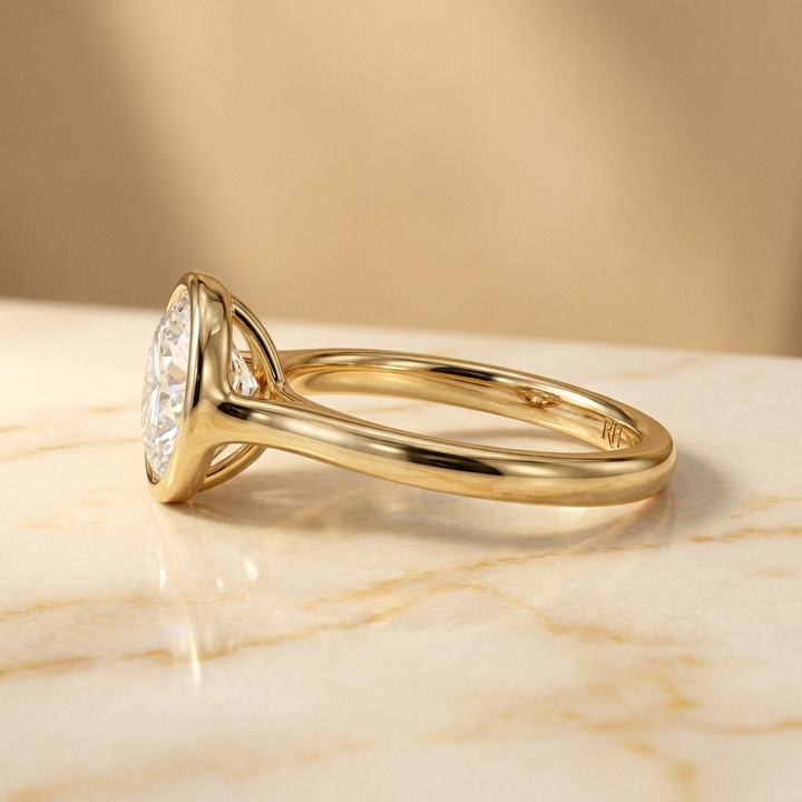 The Agnes Select bezel solitaire round brilliant engagement ring in 18k yellow gold — side profile — RockHer