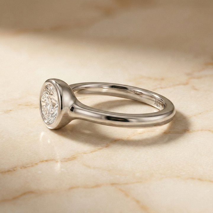 The Agnes Select bezel solitaire round brilliant engagement ring in platinum — side profile — RockHer