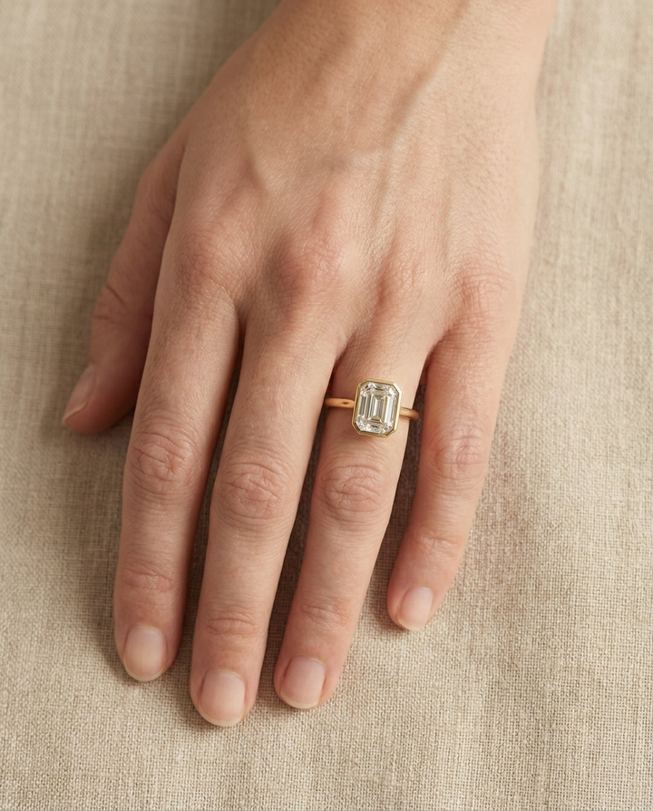 The Agnes Select bezel solitaire square emerald engagement ring in 18k yellow gold — top down hand — RockHer