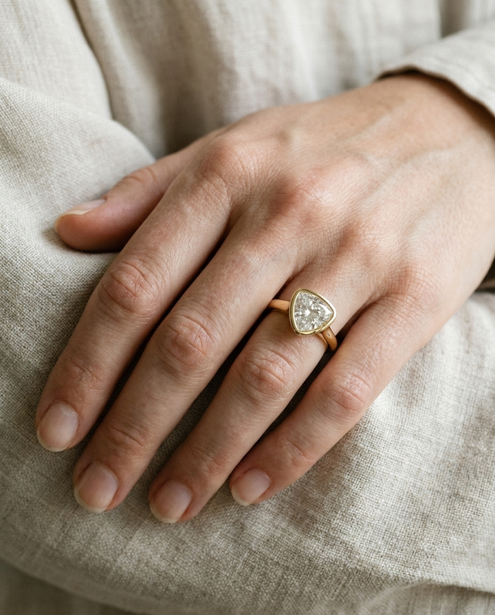The Agnes Select bezel solitaire shield engagement ring in 18k yellow gold — on hand — RockHer