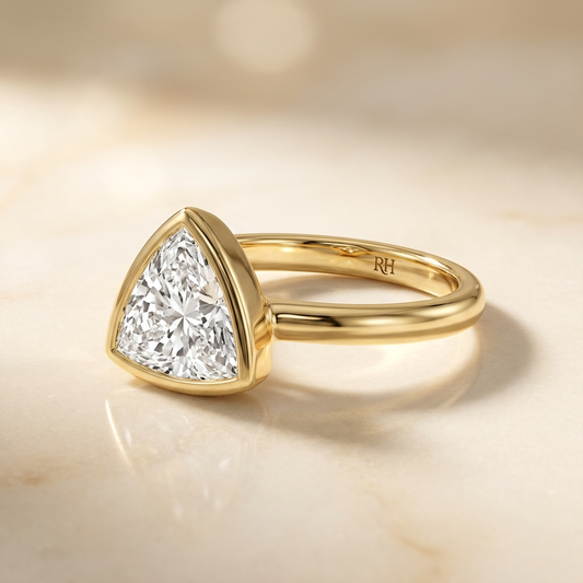 The Agnes Select bezel solitaire trillion engagement ring in 18k yellow gold — alt-angle hero — RockHer