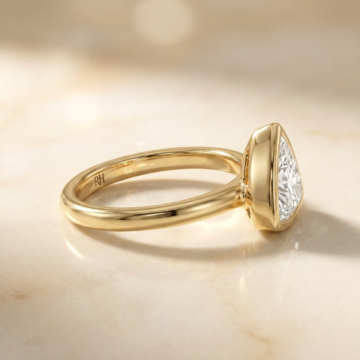 The Agnes Select bezel solitaire trillion engagement ring in 18k yellow gold — side profile — RockHer