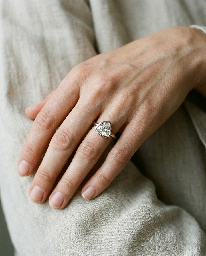 The Agnes Select bezel solitaire trillion engagement ring in 18k white gold — on hand — RockHer