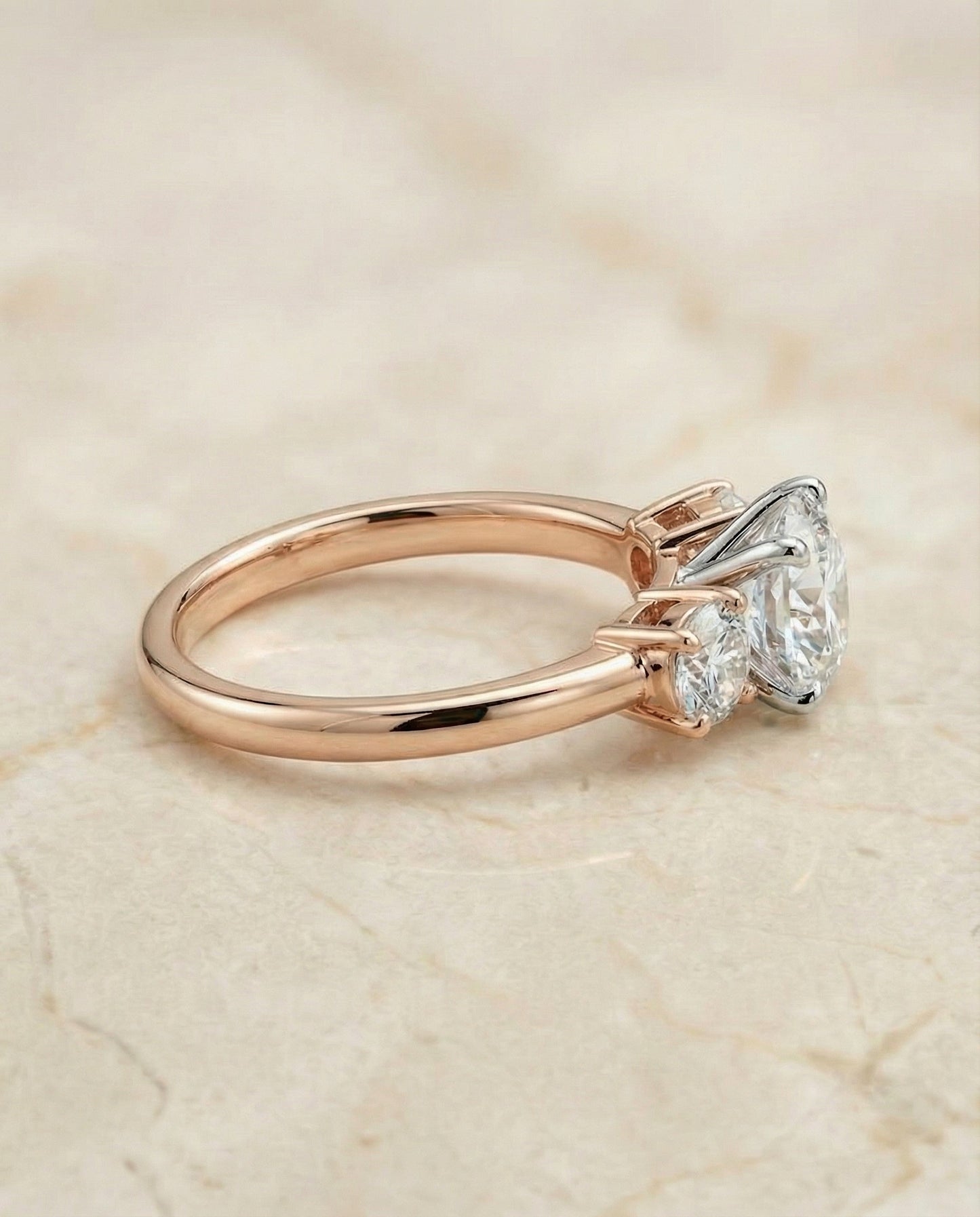 Round Brilliant, Classic Three Stone Round, in 14K Rose Gold, prong setting – side profile | RockHer