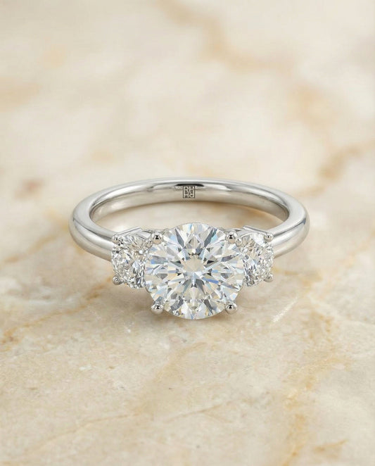 Round Brilliant, Classic Three Stone Round, in Platinum, prong setting – angled view | RockHer