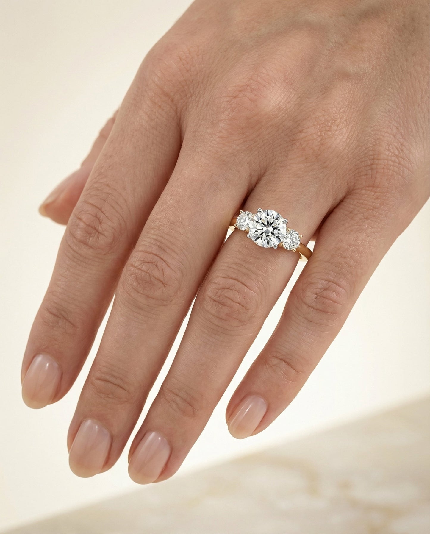 Round Brilliant, Classic Three Stone Round, in 18K Yellow Gold, prong setting – lifestyle shot | RockHer