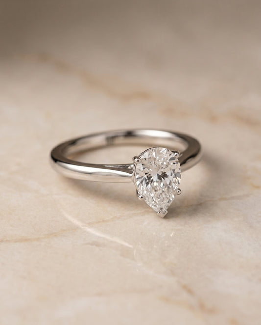 Comfort Fit Secret Stone Solitaire Pear Shape, in Platinum – angled view | RockHer