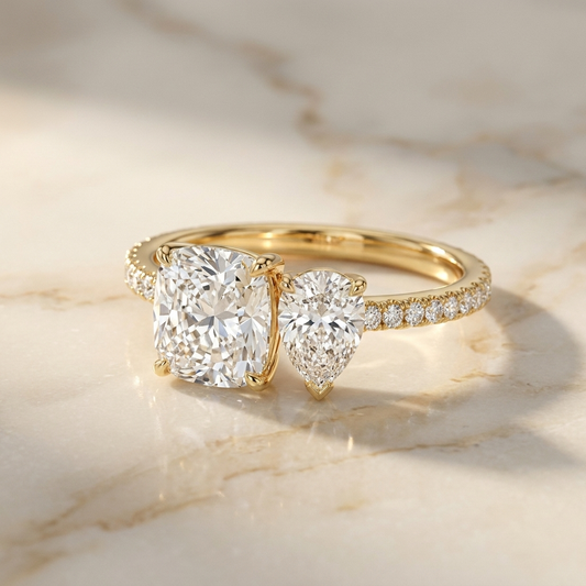 The Diana — Toi et Moi Cushion & Pear Pavé Band - Hero on warm marble