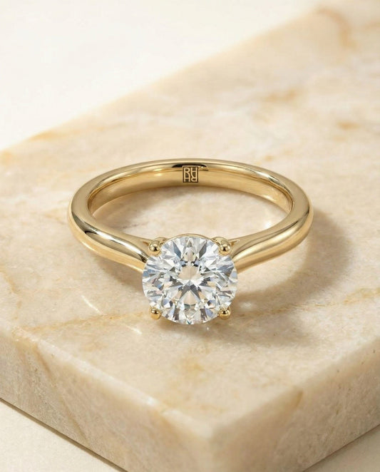 Round Brilliant, Pinched Cathedral Solitaire, in 18K Yellow Gold, prong setting – angled view | RockHer