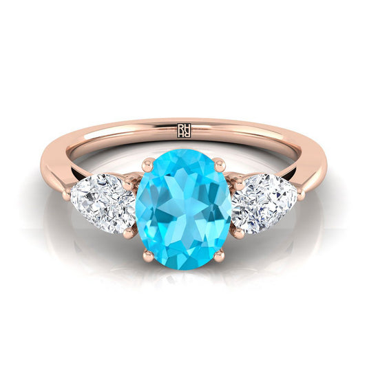 แหวนหมั้นเพชรสามเม็ดรูปทรงลูกแพร์ที่เข้าคู่กันอย่างสมบูรณ์แบบ ประดับด้วยทับทิมสวิสสีน้ำเงินรูปวงรีทองกุหลาบ 14K น้ำหนักรวม 7/8 กะรัต