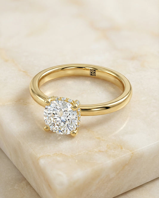 Secret Halo Adorned Prong Solitaire Cushion, in 18K Yellow Gold – angled view | RockHer