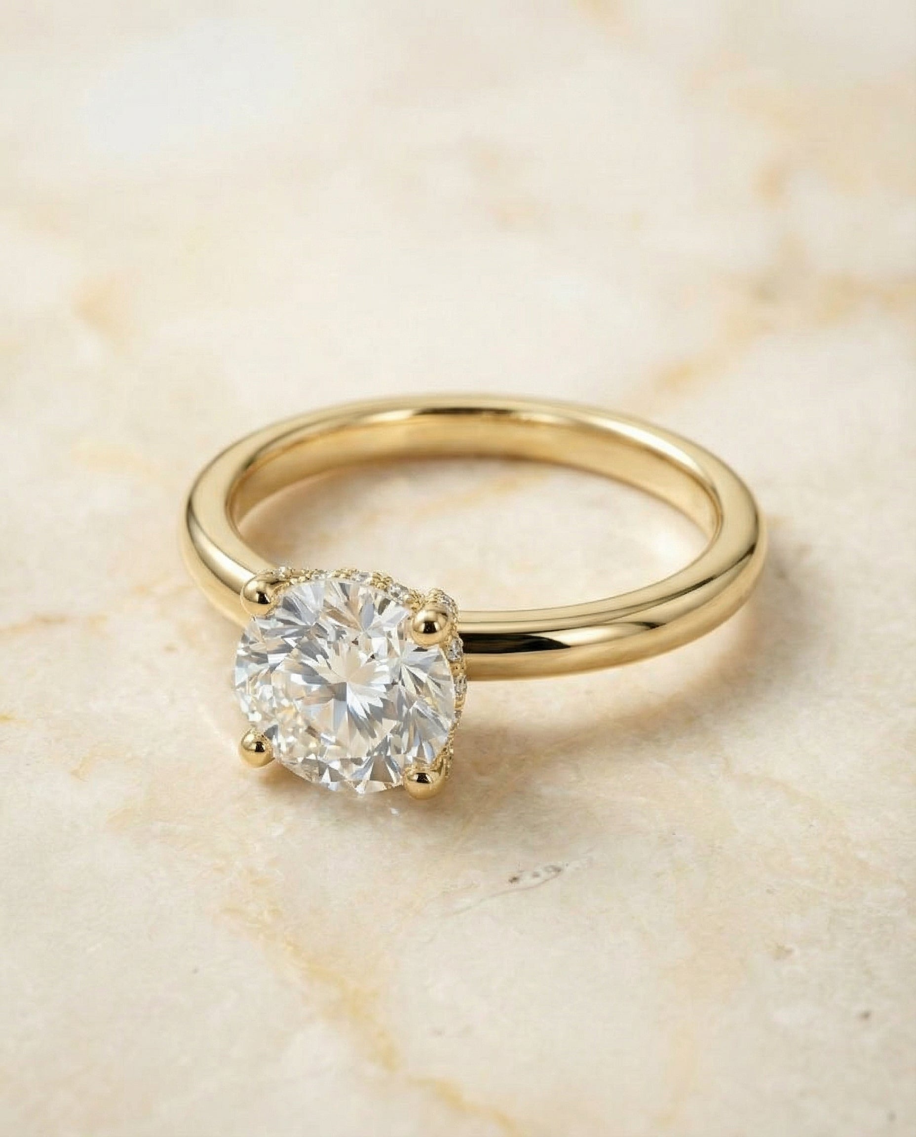 Round Brilliant, Secret Halo Adorned Prong Solitaire, in 18K Yellow Gold – angled view | RockHer