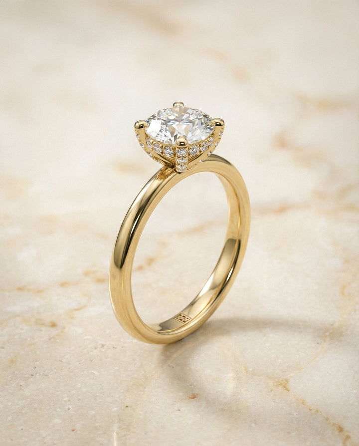 Round Brilliant, Secret Halo Adorned Prong Solitaire, in 18K Yellow Gold – front view | RockHer